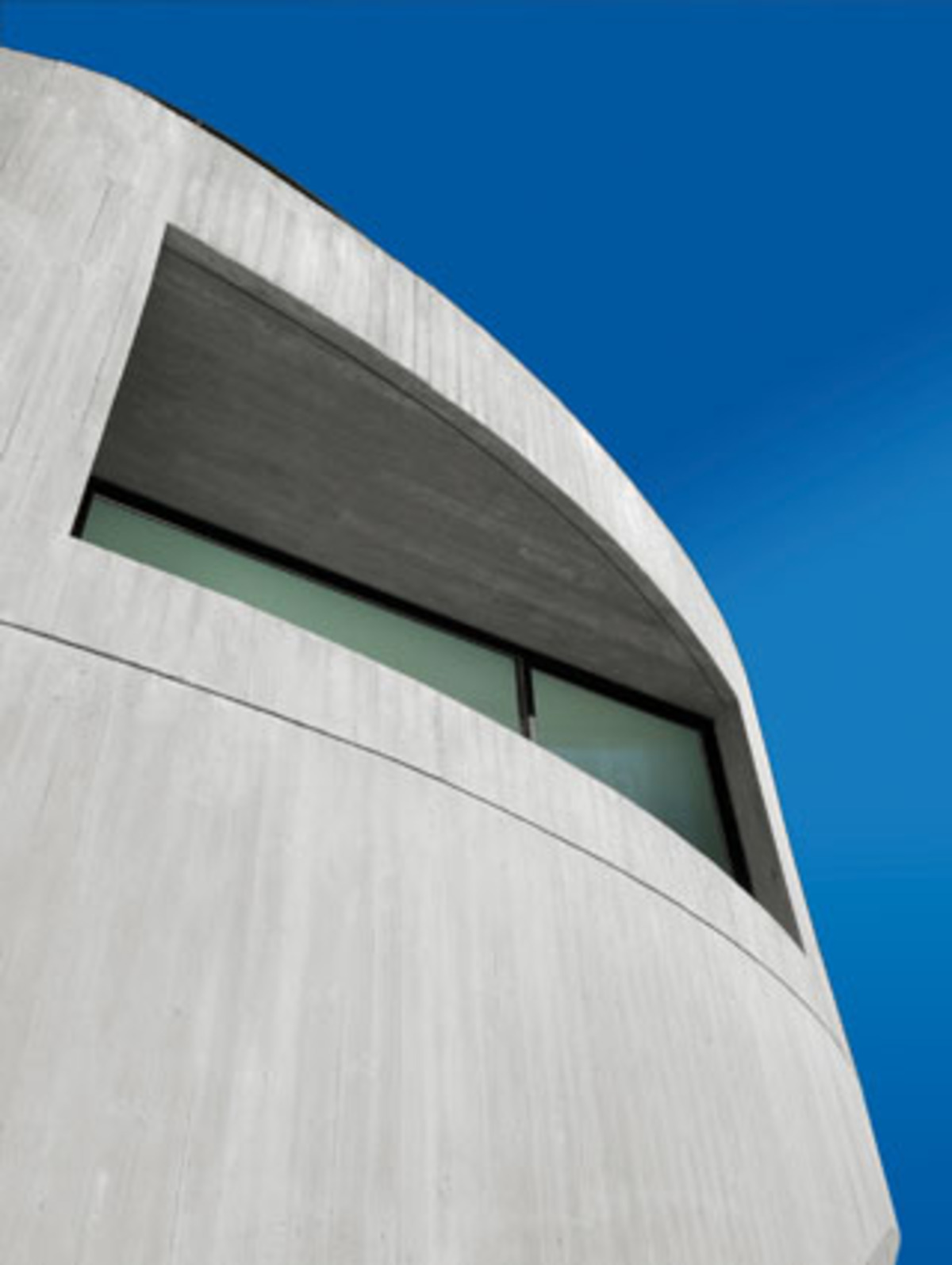 Für den Bau verabschiedete man sich großteils von traditionellen Formen. Die glatten Oberflächen gehen nahtlos ineinander über, nehmen dabei aufeinander Bezug und lassen den Eindruck von Rotation entstehen.