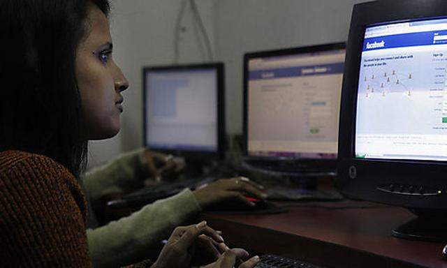 A girl surfs a Facebook page at an Internet cafe in Gauhati, India