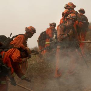 Häftlinge in ihren orangen Overalls bei der Eindämmung des Feuers in Pacific Palisades. 