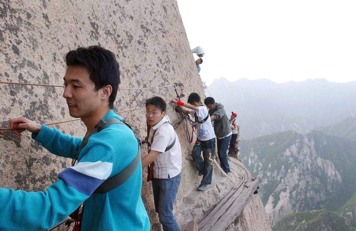 Auf 30 Zentimeter schmalen Holzbrettern kann man mit dem Berg in der Shaanxi-Provinz auf Tuchfühlung gehen. Mittlerweile gibt es sehr viele Touristen und bessere Sicherheitsstandards, doch gefährlich ist der Kletterpfad noch immer. Vor allem, wenn man Selfies mit von sich gestreckten Händen und Beinen macht.