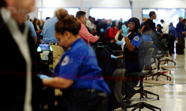 TSA agents screen passengers at a security checkpoint at Hartsfield-Jackson Atlanta International Airport amid the partial federal government shutdown, in Atlanta