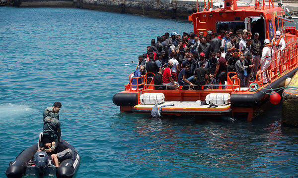 A migrant is rescued by Spanish civil guards after jumping into the sea from the rescue boat upon arrival at the port of Tarifa