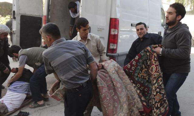 Civilians transport casualties after what activists said was shelling by forces loyal to Syria's President Bashar al-Assad after Friday prayers in the Damascus suburb of Saqba