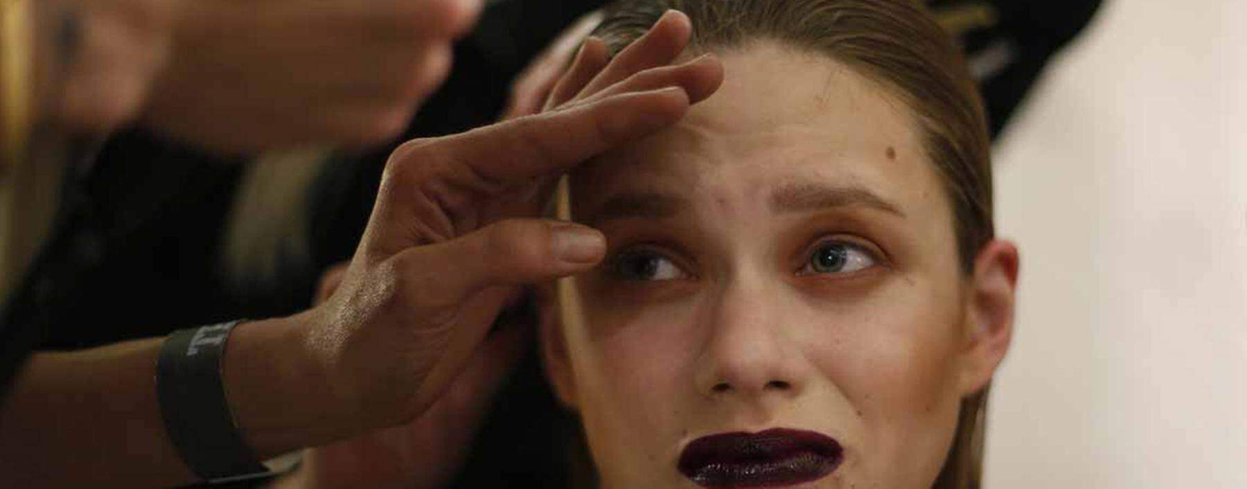 A model undergoes preparations backstage before presentation of Portuguese designer Dino Alves Fall-Winter 2013/2014 collection during Lisbon Fashion Week