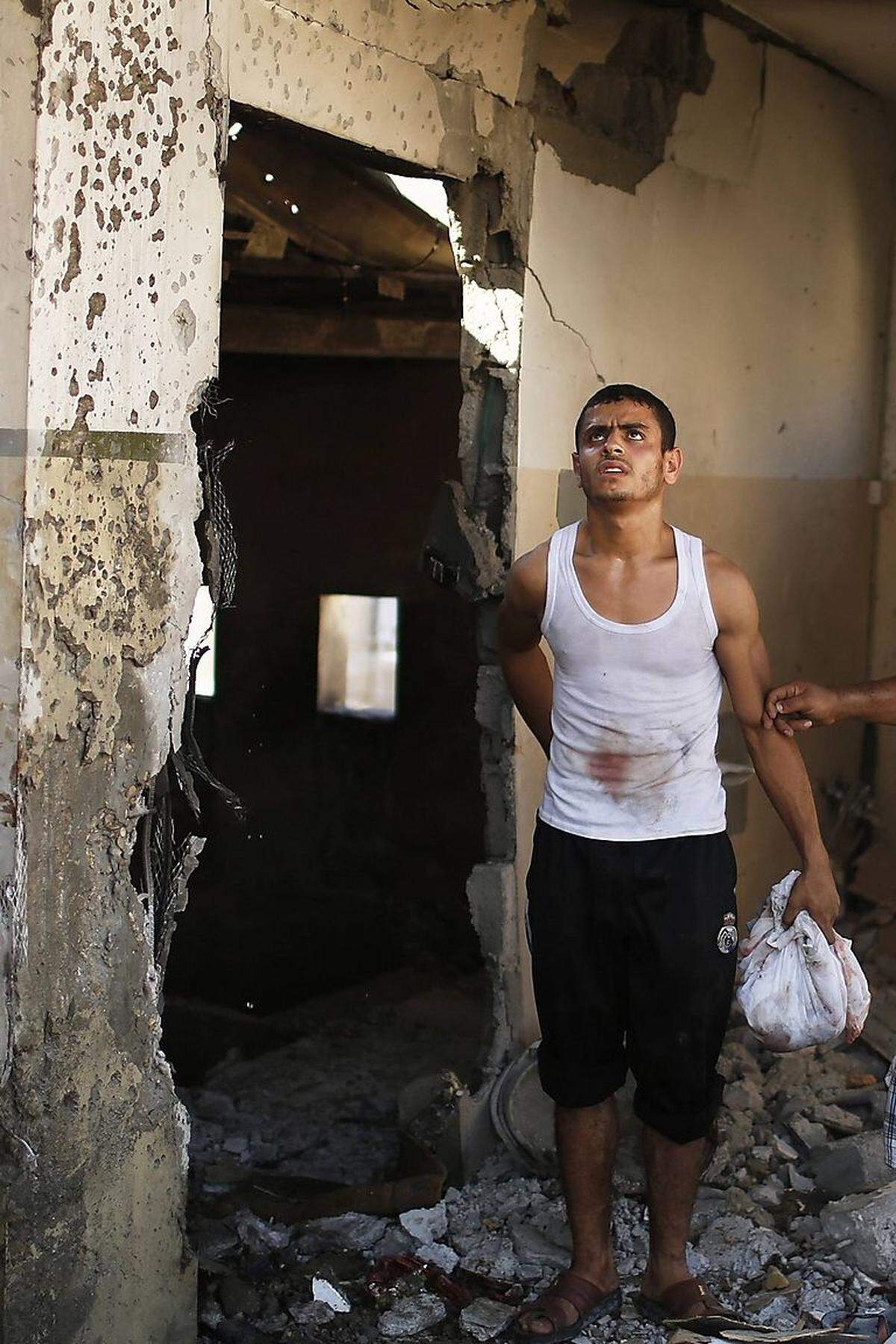 Nur Tod und Zerstörung: Ein Palästinenser in Gaza-Stadt in den Ruinen eines bombardierten Hauses - in Händen ein Kleidungsstück, in dem er menschliche Überreste aus den Trümmern geborgen hat.