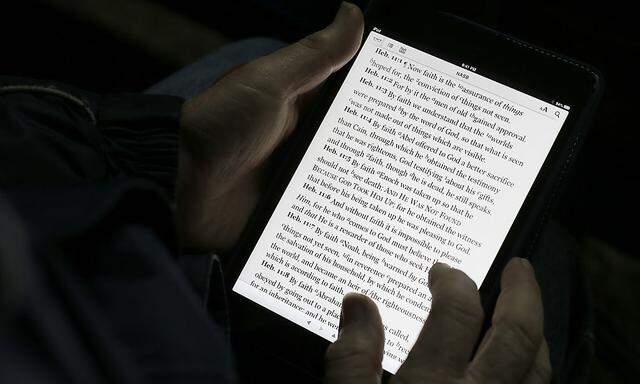 A man reads the bible from an iPad mini at the ´Christ is the Answer International Ministries´ group´s camp near Florence