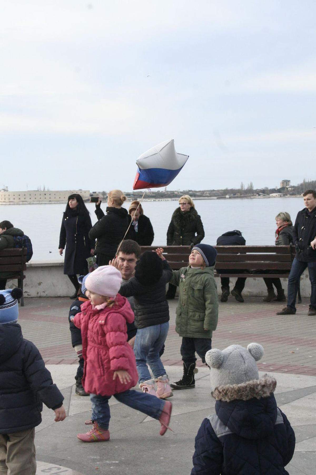 Kinder mit Luftballons in russischen Nationalfarben an der Uferpromenade von Sewastopol.