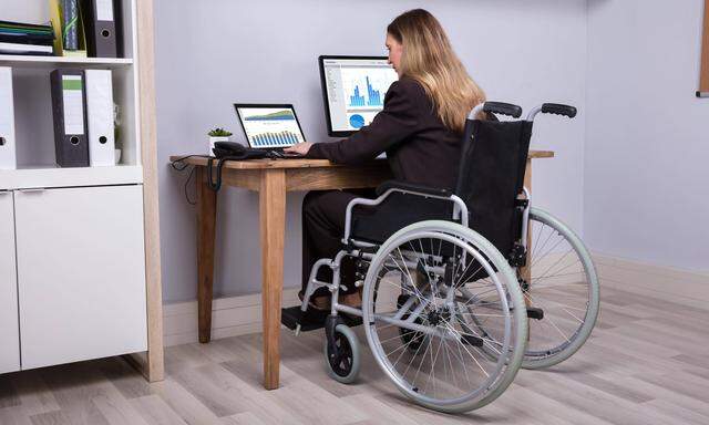 Disabled Businesswoman Working On Computer model released Symbolfoto PUBLICATIONxINxGERxSUIxAUTxO