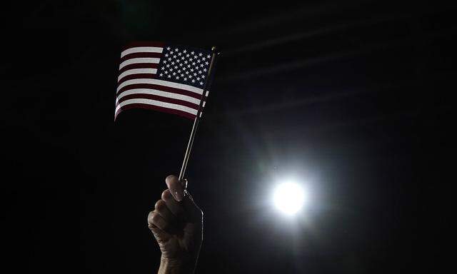 A supporter waves a U.S. flag as Democratic presidential candidate and former South Bend, Indiana Mayor Pete Buttigieg speaks at his rally at Drake University in Des Moines, Iowa, U.S.