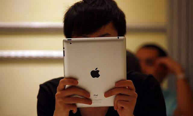 A man looks at his iPad while sitting in a cafe in central Beijing
