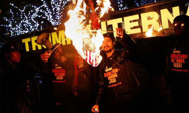 Aktivisten verbrennen die US-Flagge.