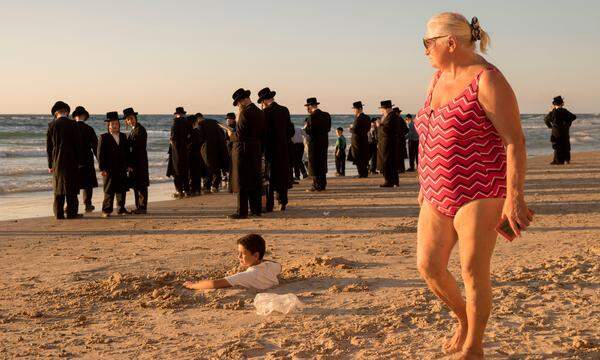 Ultraorthodoxe und Badegäste am Strand bei Tel Aviv.   