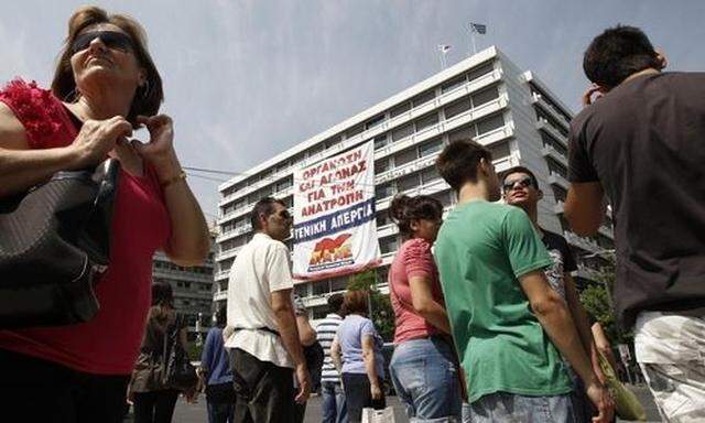 A huge banner, unfolded by the Greek Communist-affiliated trade union PAME, is hung from the Greek Fi