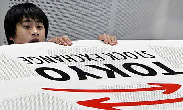 A dealer at Tokyo Stock Exchange reacts during afternoon trading in Tokyo as Japans benchmark Nikkeis benchmark Nikkei