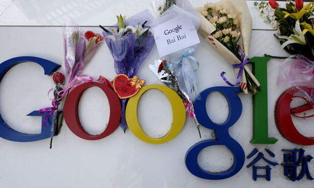 Flowers put by Chinese Google users are seen on its sign outside the Google China headquarters in Bei