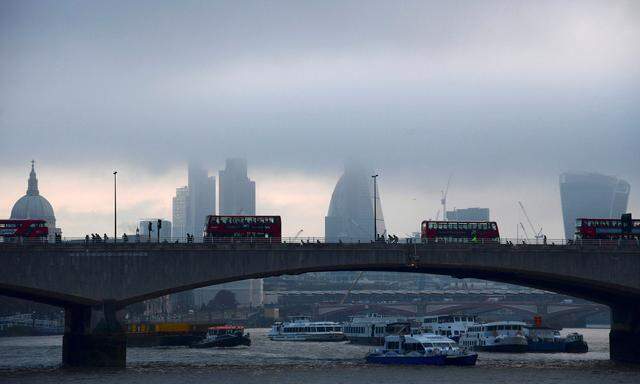 FILE PHOTO:  City workers cross the River Thames with the City of London financial district seen behind in London