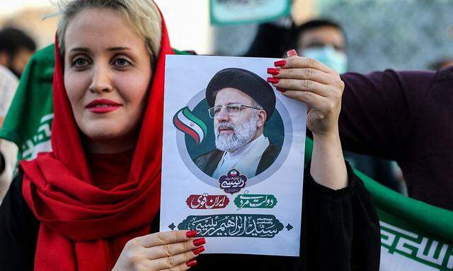  Eine Iranerin hält ein Bild von Ebrahim Raisi bei einer Straßenfeier nach dessen Wahlsieg in Teheran im Juni.