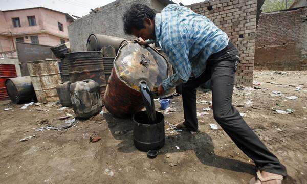Ein Arbeiter in Indien leert Motoröl in einen Kübel. Der südasiatische Staat baut auf Öl aus Russland.