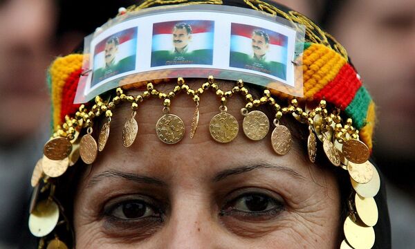 Eine kurdische Frau trägt das Konterfei Abdullah Öcalans