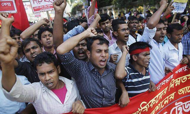 Activists and garment workers shout slogans during a protest demanding a minimum wage of 8,000 Bangladeshi Taka in Dhaka