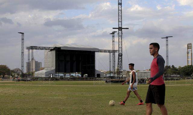 A man walks with a soccer ball in front of the stage to be used for the Rolling Stones´ free outdoor concert on March 25 at Ciudad Deportiva de la Habana sports complex, Havana