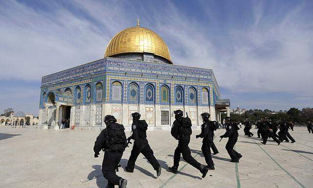 Israeli policemen run in front of the Dome of the Rock during clashes with stone-throwing Palestinians after Friday prayers in Jerusalem´s Old City