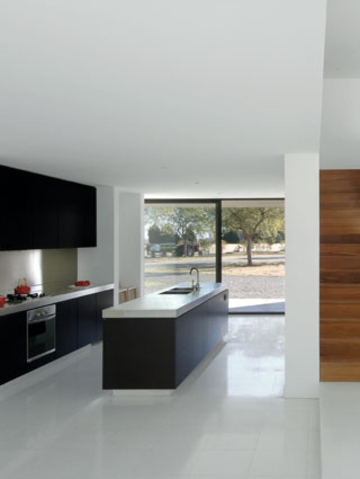 Die sozialen Bereiche wurden offen gestaltet. Der polierte Granitboden reflektiert hier einmal mehr die allerorts ins Haus dringende Lichtstimmung. Die massive Küche besteht aus Mahagoniholz und Stahl. Das Sideboard ist aus der "Eco"-Linie von Area D6.