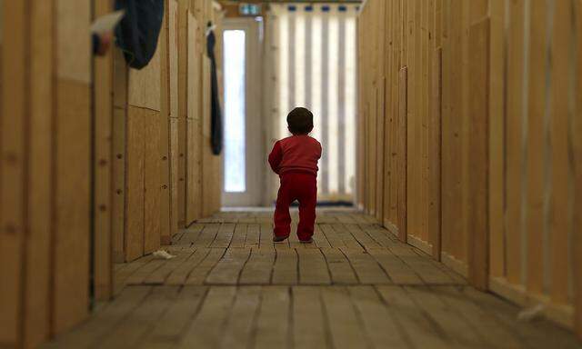 A migrant child walks through the first registration camp of Erding near Munich