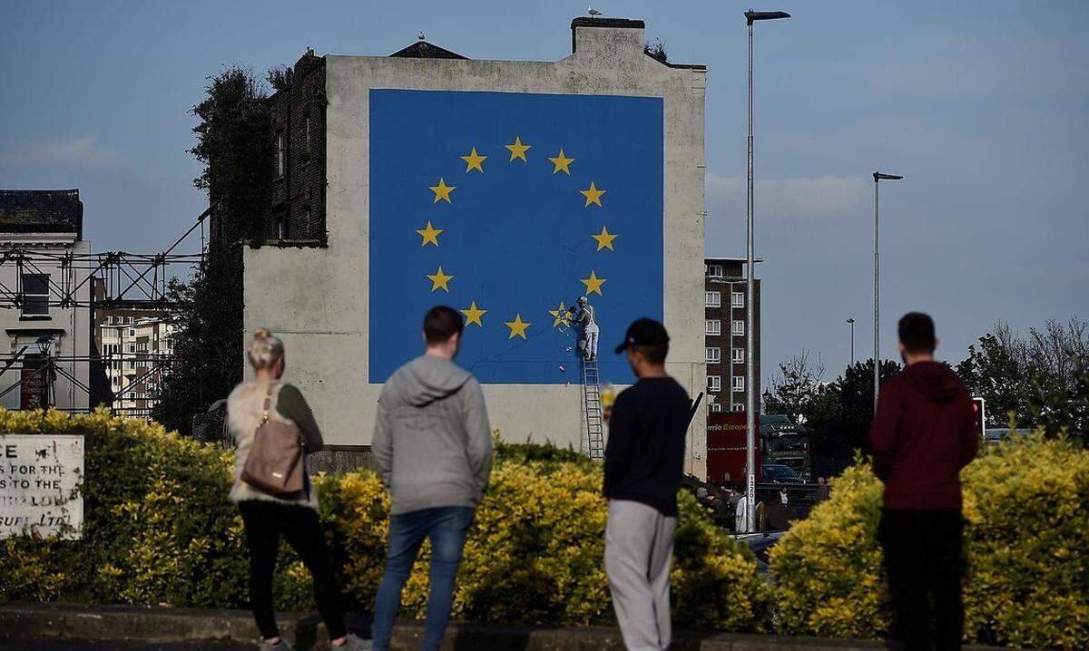 Eine mehrere Meter hohe quadratische EU-Flagge, aus der ein Handwerker einen Stern heraus meißelt: Dieses Bild hinterließ Banksy im Mai 2017 im englischen Dover.