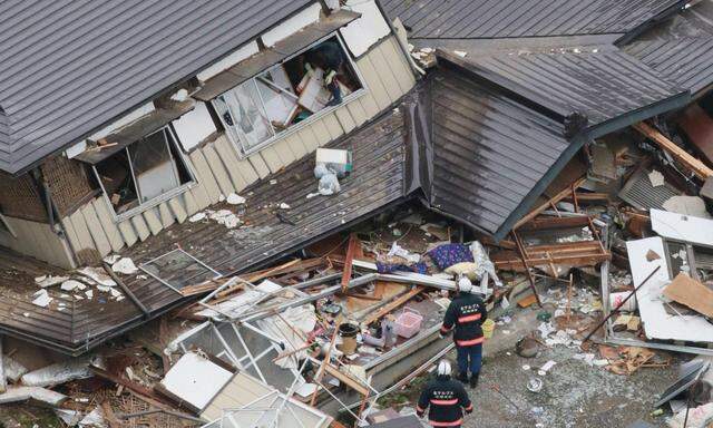 An aerial view shows rescue workers investigating at collapsed houses after an earthquake in Hakuba town
