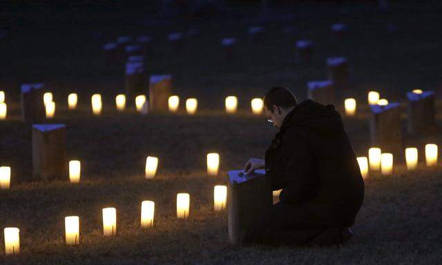 A man pays his respects during a commemoration ceremony for the 70th anniversary of the liberation of Auschwitz death camp, at the Jewish Cemetery in former Nazi concentration camp Terezin in Terezin