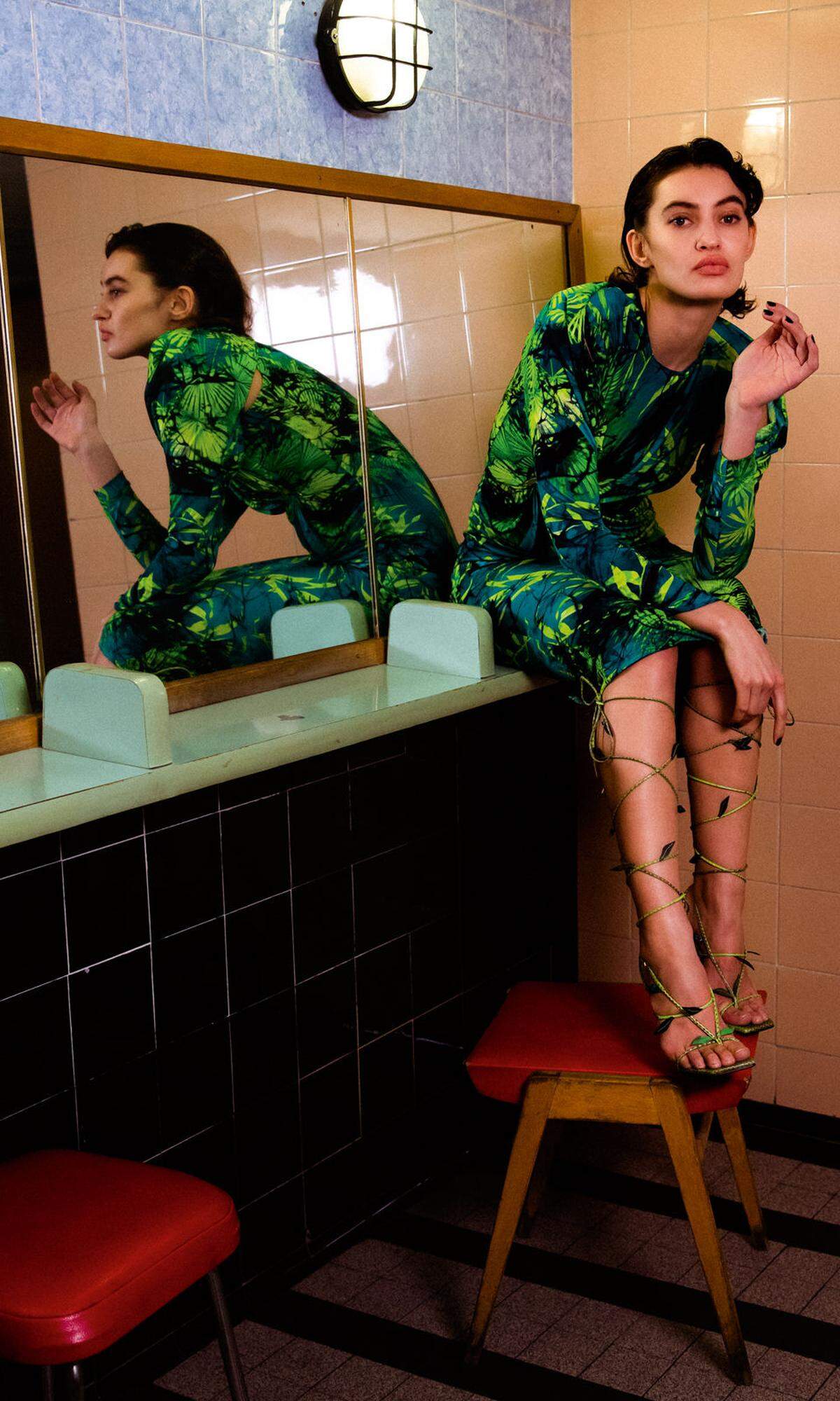 Marina trägt ein Seidenkleid im Jungle Print und Riemchensandalen.