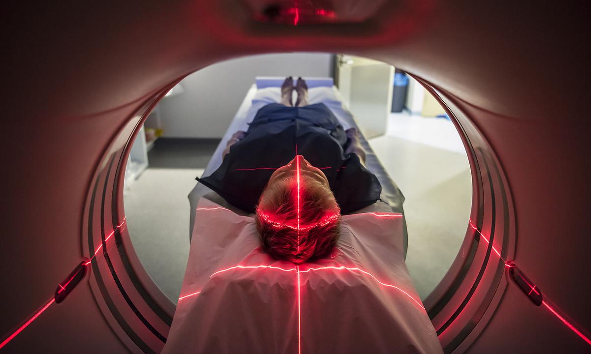 Patient lying inside a medical scanner in hospital