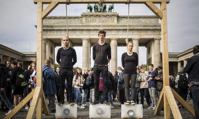 Aktion vor dem Brandenburger Tor in Berlin mit schmelzenden Eisblöcken. Währenddessen stellte die Regierung einen Aktionsplan fürs Klima vor.
