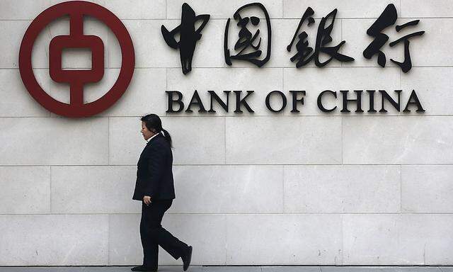 File photo of a woman walking past a sign of Bank of China at its branch in Beijing