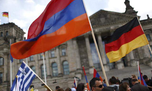 Supporters wave Armenian and German flags in front of the Reichstag in Berlin