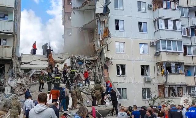 Rettungskräfte und Anwohner bei einer Such- und Rettungsaktion an einem teilweise eingestürzten Wohnblock nach einen russischen Raketenangriff 
