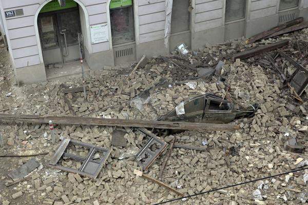 Ein vor dem Gebäude abgestellter Pkw wurde unter den herabfallenden Trümmern begraben.