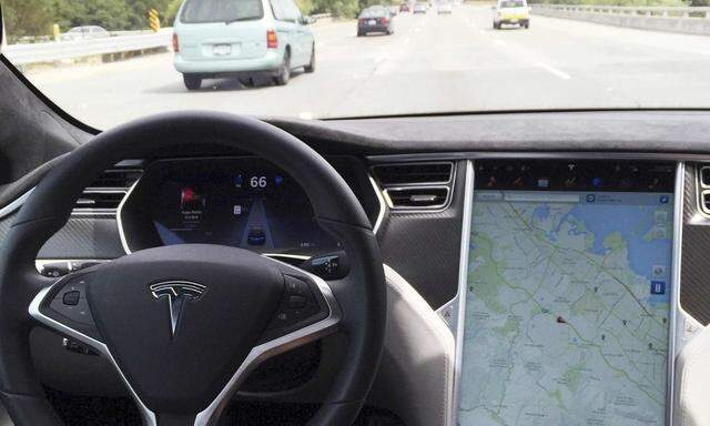The interior of a Tesla Model S is shown in autopilot mode in San Francisco