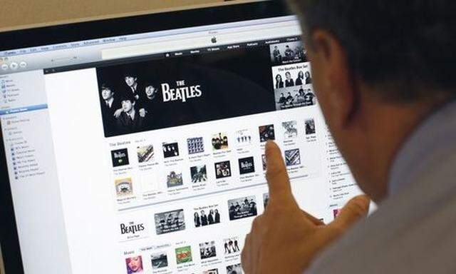 A man poses as he looks at music from the legendary band The Beatles on Apples itunes music store wes itunes music store we