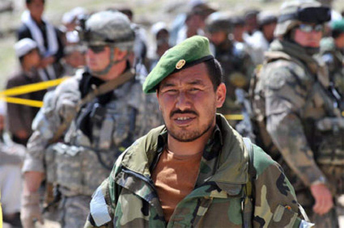 Afghanischer Armee-Offizier im Vordergrund, hinten zwei US-Soldaten, Verteilung von Hilfsgüptern in Sultankhel, Provinz Kapisa.