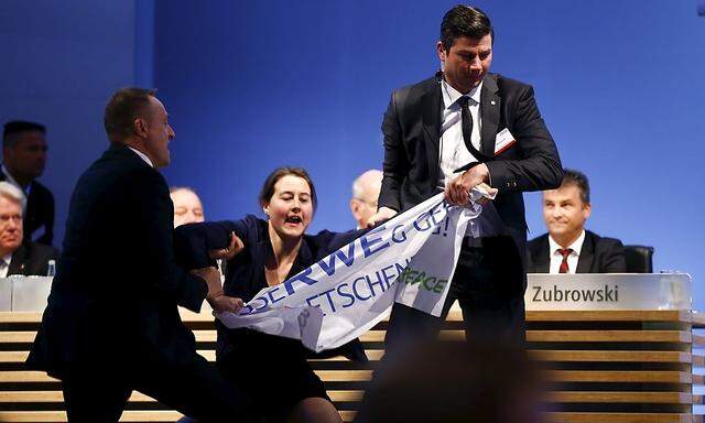 An environment activist is pulled from stage during the annual shareholders meeting of German power supplier RWE in Essen