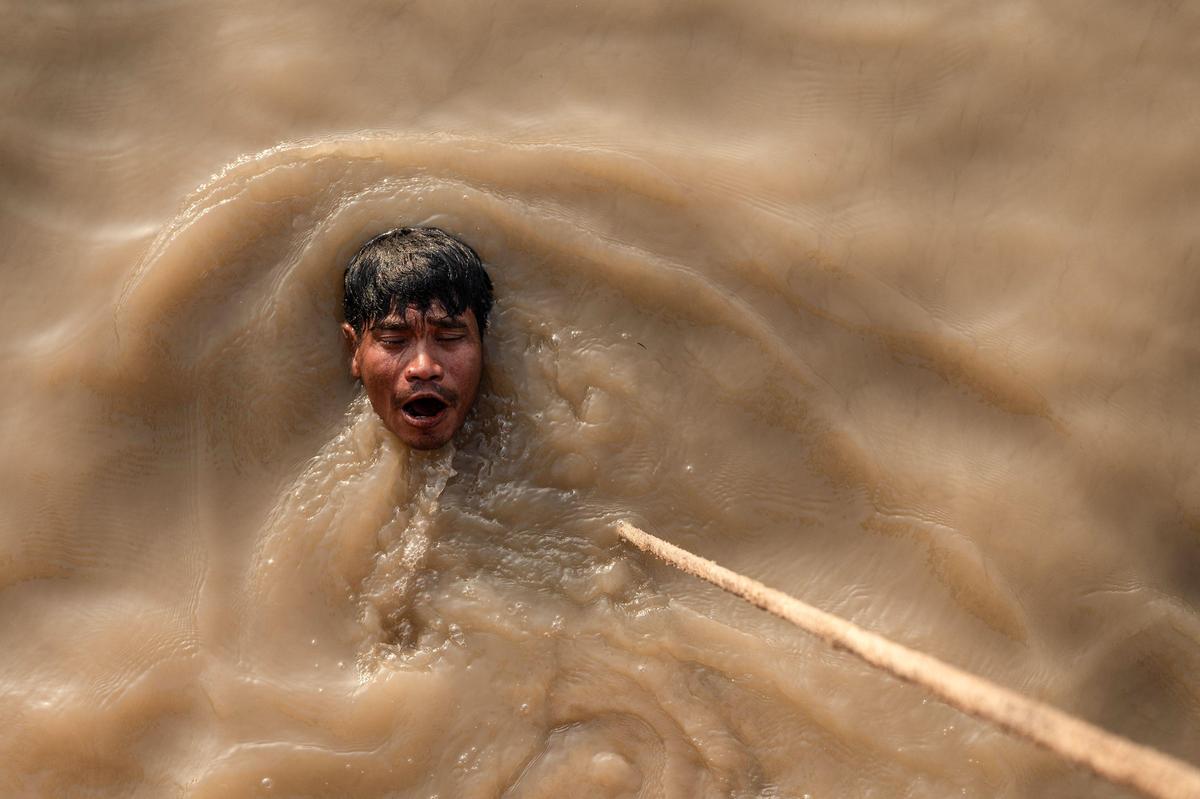 25. April. In Rangun in Myanmar taucht ein Mann im Yango-Fluss nach einem versunkenen Schiff.