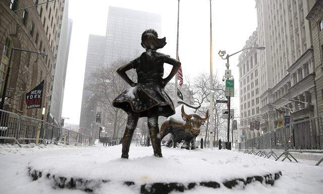 Snow falls on the The Fearless Girl statue facing the Charging Bull in a snow storm in New York City