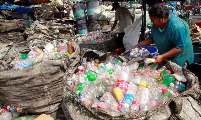 FILE PHOTO: People sort through plastic bottles in Manila