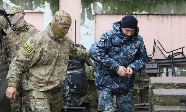 Keine schnelle Freilassung: Ein FSB-Mitarbeiter (links) führt einen ukrainischen Marinesoldaten in das Gerichtsgebäude.