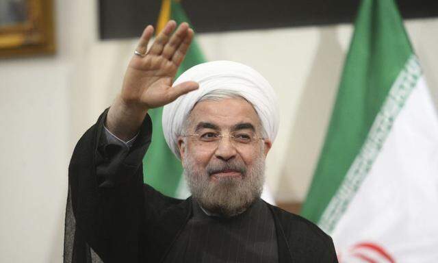 Iranian President-elect Hassan Rohani gestures to the media during a news conference in Tehran