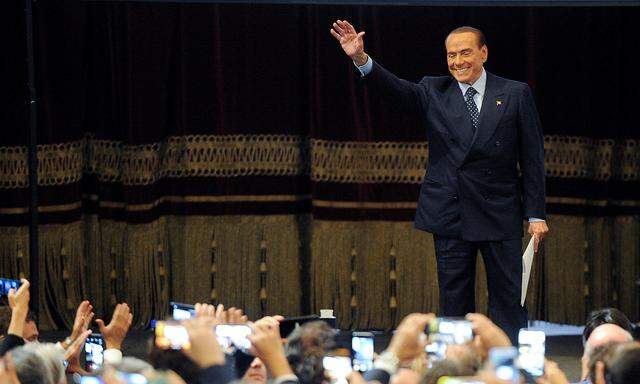 Forza Italia party leader Silvio Berlusconi waves to his supporters during a rally for the regional election in Palermo