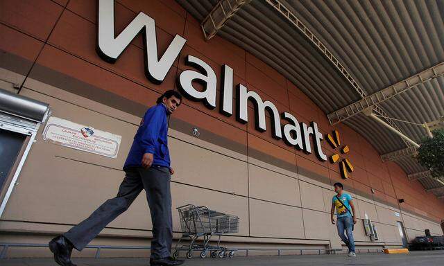 FILE PHOTO: Shoppers walk from a Wal-Mart store in Mexico City