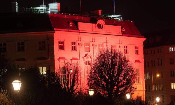 Das Kanzleramt in Wien ist in oranges Licht gehüllt.